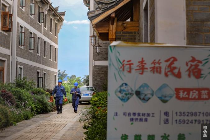3 供电所员工在避暑游客主要聚集点，开展线路巡维工作（杜明彦 摄）