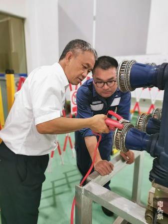 高压试验专业人员参加云南电网公司组织的技能比武之前，何彪对他们进行实操培训。